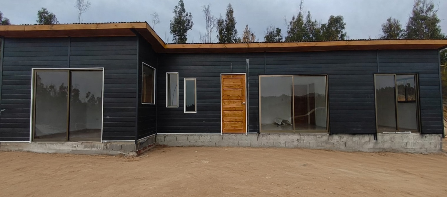 Casa Metalcon negra con puerta de madera