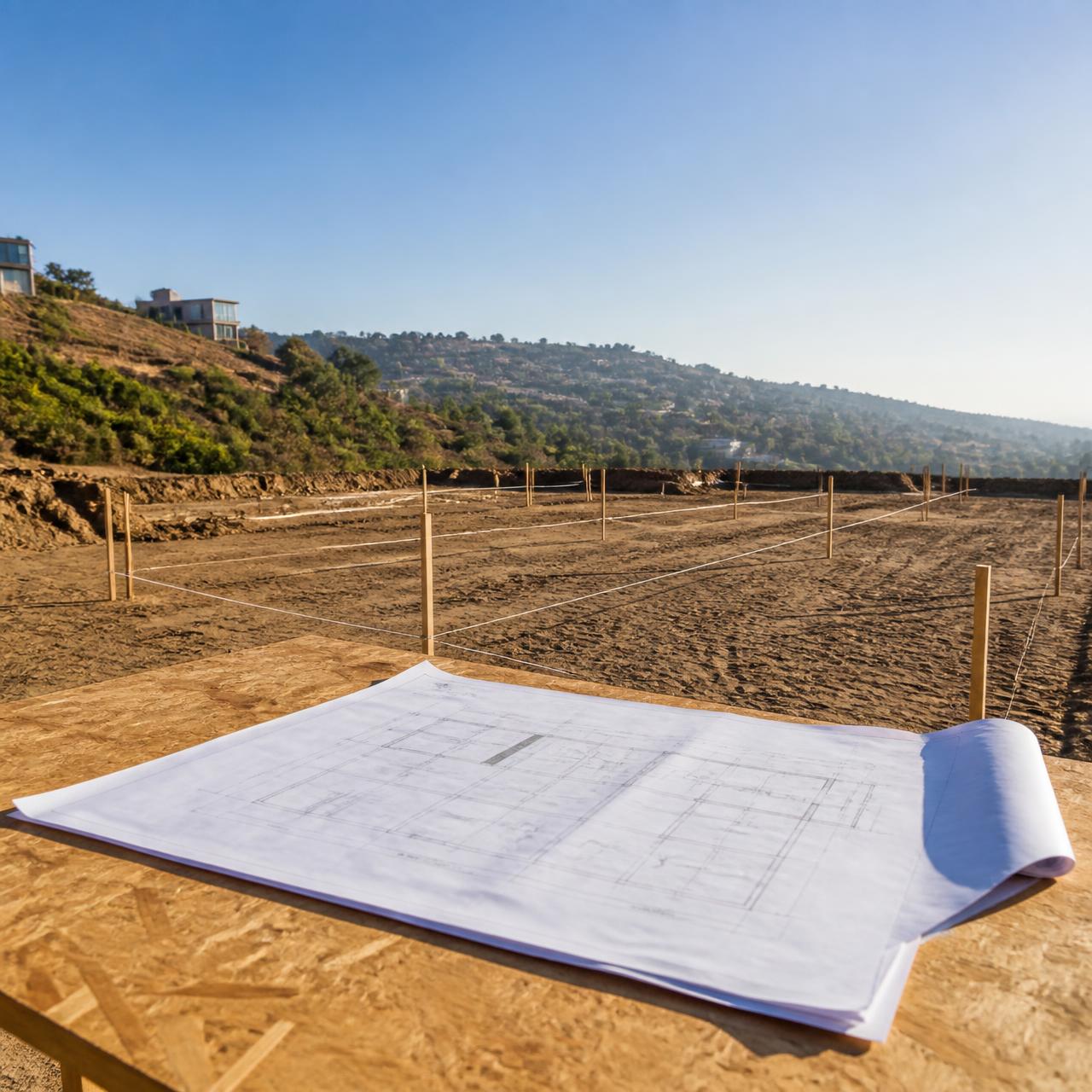 Terreno preparado con planos del proyecto (IMAGE_PLACEHOLDER_PROJECT)